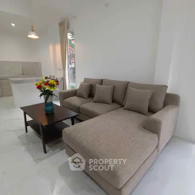 Modern living room with cozy sectional sofa and elegant coffee table in open layout.
