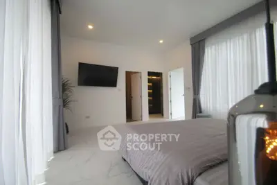Spacious modern bedroom with elegant decor and large windows