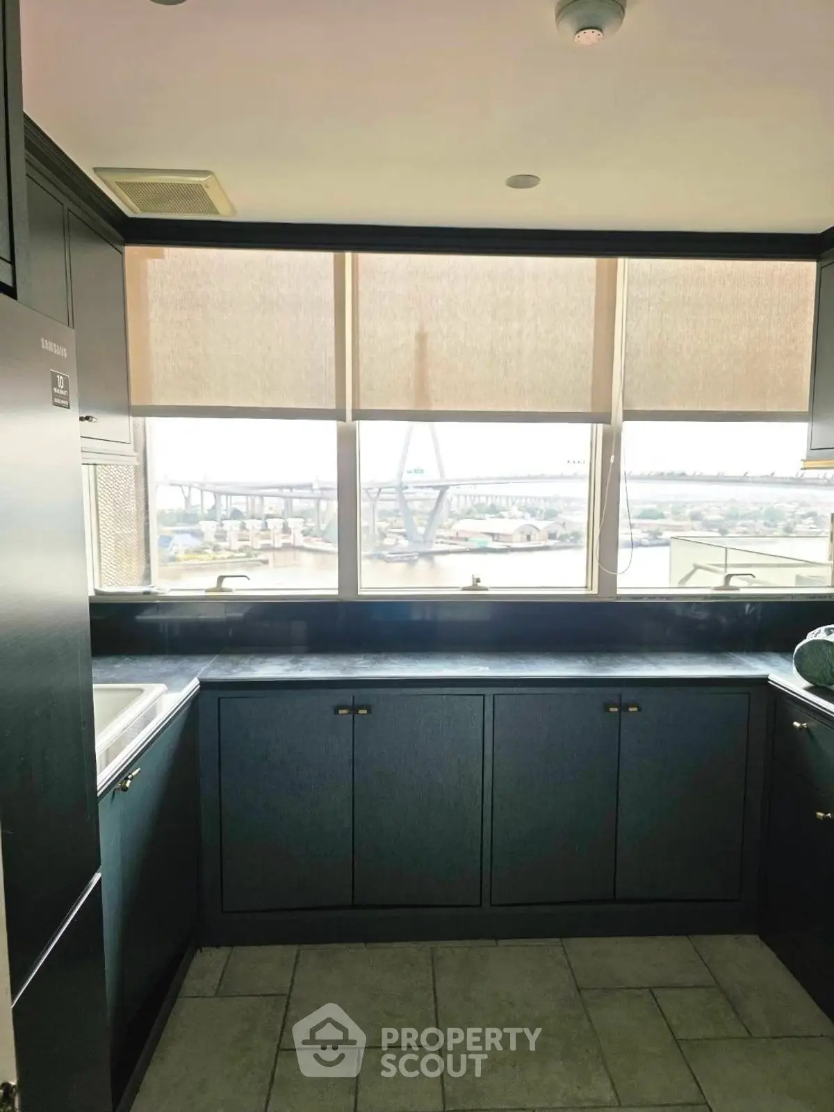 Modern kitchen with sleek cabinetry and stunning bridge view from window.