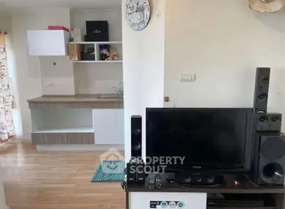 Cozy living room with modern entertainment setup and open kitchen layout, perfect for urban living.