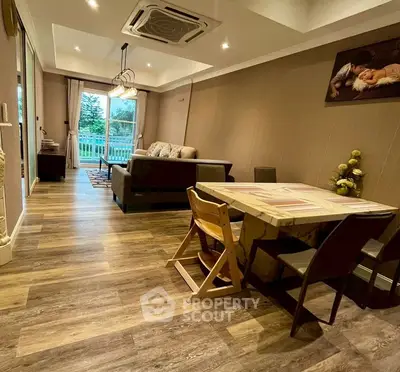Spacious living room with modern decor and large windows offering a serene garden view.