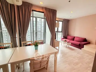 Spacious living room with modern decor and large windows offering city views.