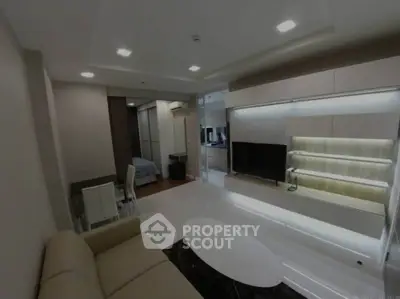 Modern living room with sleek furniture and integrated TV unit in a stylish apartment.