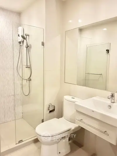 Modern bathroom with glass shower, sleek fixtures, and elegant design.