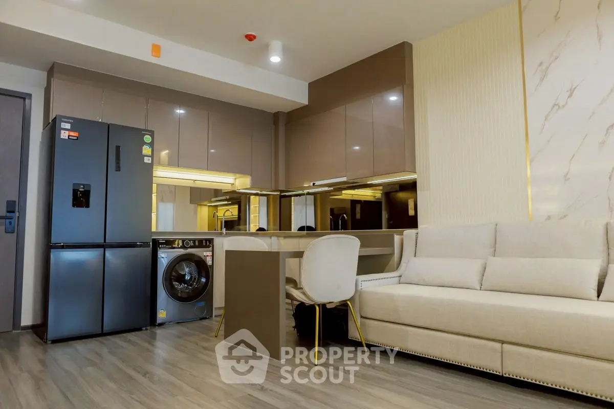 Modern open-layout kitchen and living room with sleek appliances and stylish decor.