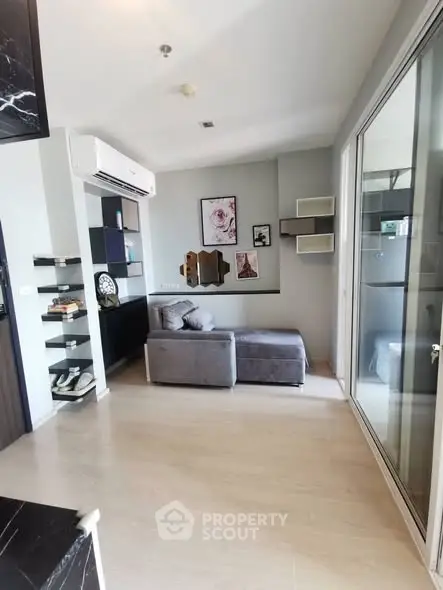 Modern living room with stylish decor and glass partition in a cozy apartment.