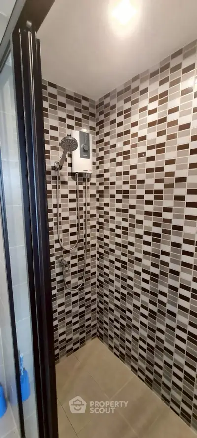Modern bathroom shower area with stylish tile design and overhead shower
