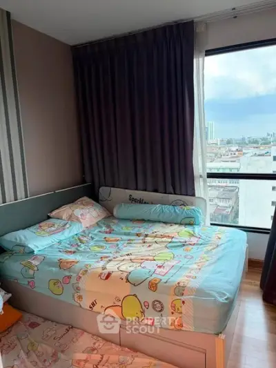 Cozy bedroom with large window offering city views, featuring playful bedding and modern decor.
