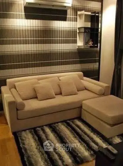 Stylish modern living room with cozy beige sofa and chic striped wallpaper.