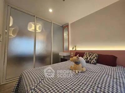 Cozy bedroom with modern decor and plush bedding, featuring a frosted glass wardrobe and soft lighting.