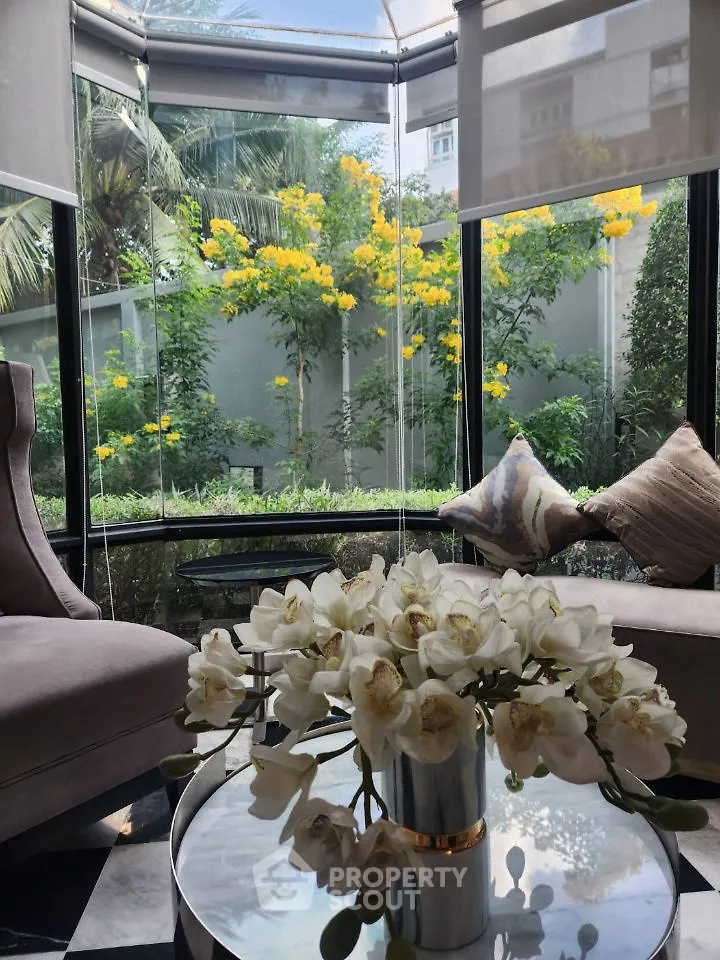 Luxurious sunlit corner with plush seating and vibrant garden view, perfect for relaxation.