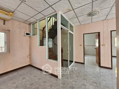 Spacious interior with unique staircase and vintage ceiling tiles, perfect for creative renovation.