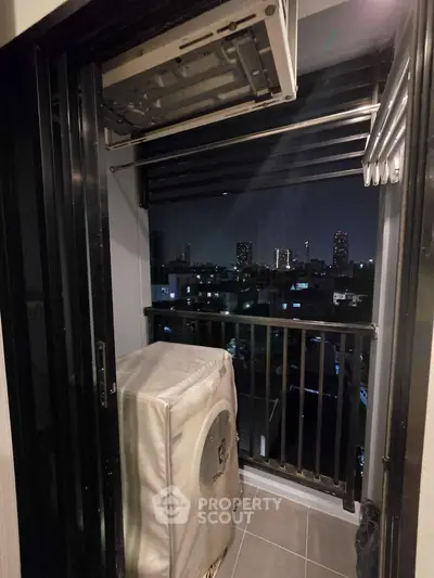 Charming balcony with laundry area and stunning city night view, perfect for urban living.