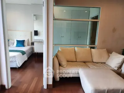 Modern apartment with cozy living room and elegant bedroom featuring wooden flooring and stylish decor.