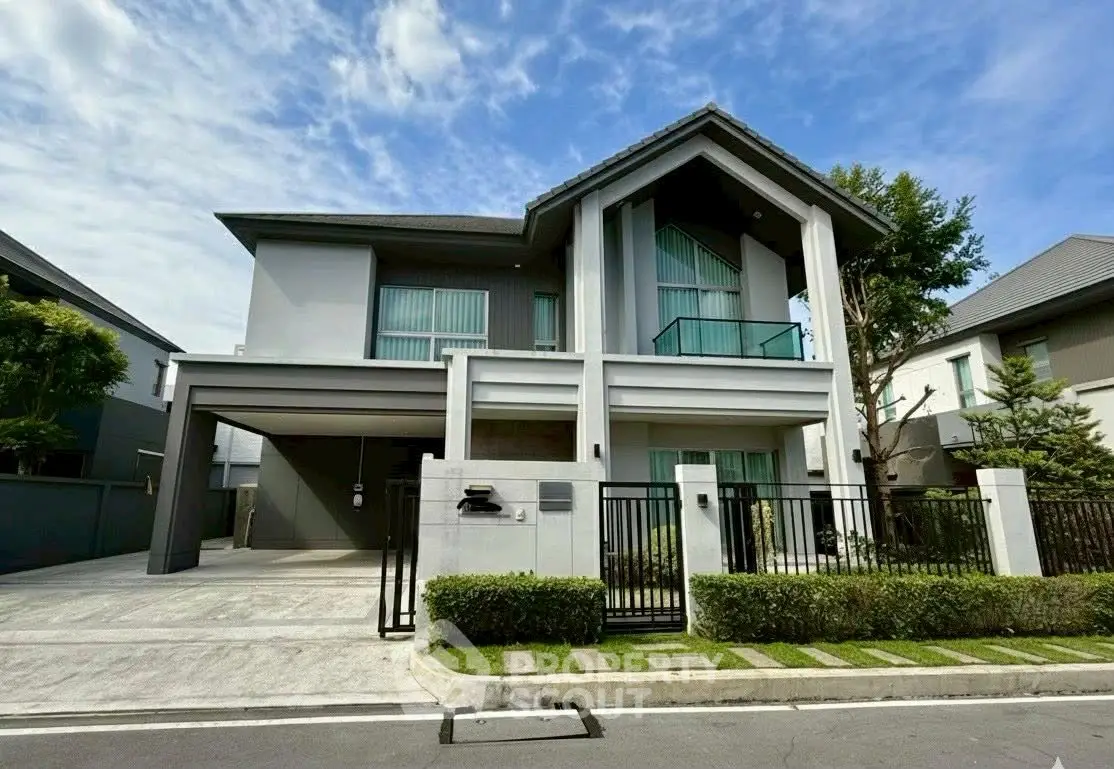 Modern two-story house with sleek design and spacious driveway in a serene neighborhood.