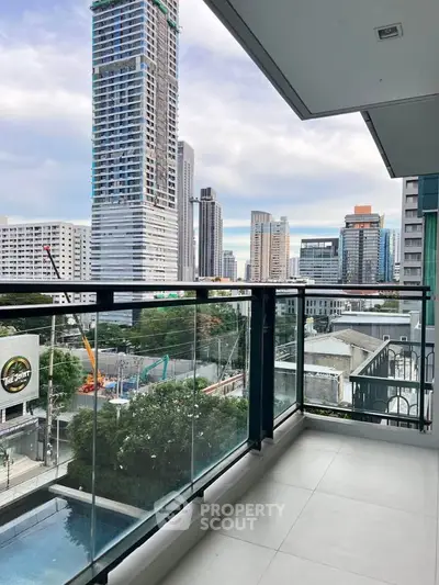 Spacious balcony with stunning cityscape views in a modern high-rise building.