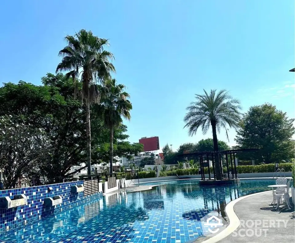 Luxurious outdoor pool area with palm trees and modern design.