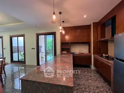 Luxurious kitchen with marble countertops and modern lighting in elegant home.