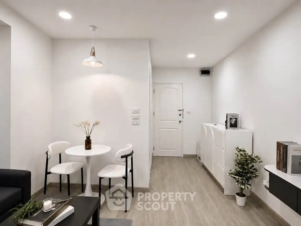 Modern minimalist living room with white furniture and wooden flooring