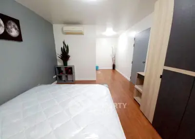 Spacious bedroom with modern decor and wooden flooring