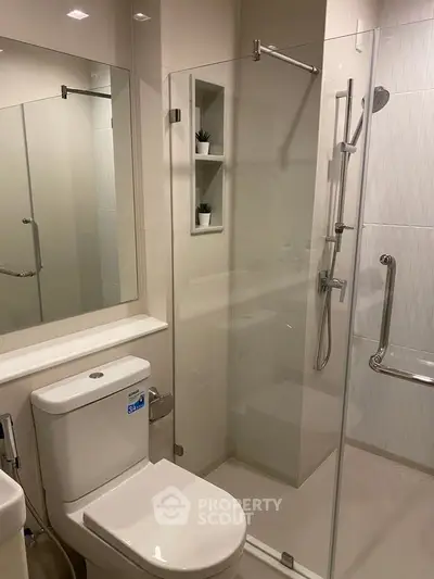 Modern bathroom with glass shower enclosure and sleek fixtures
