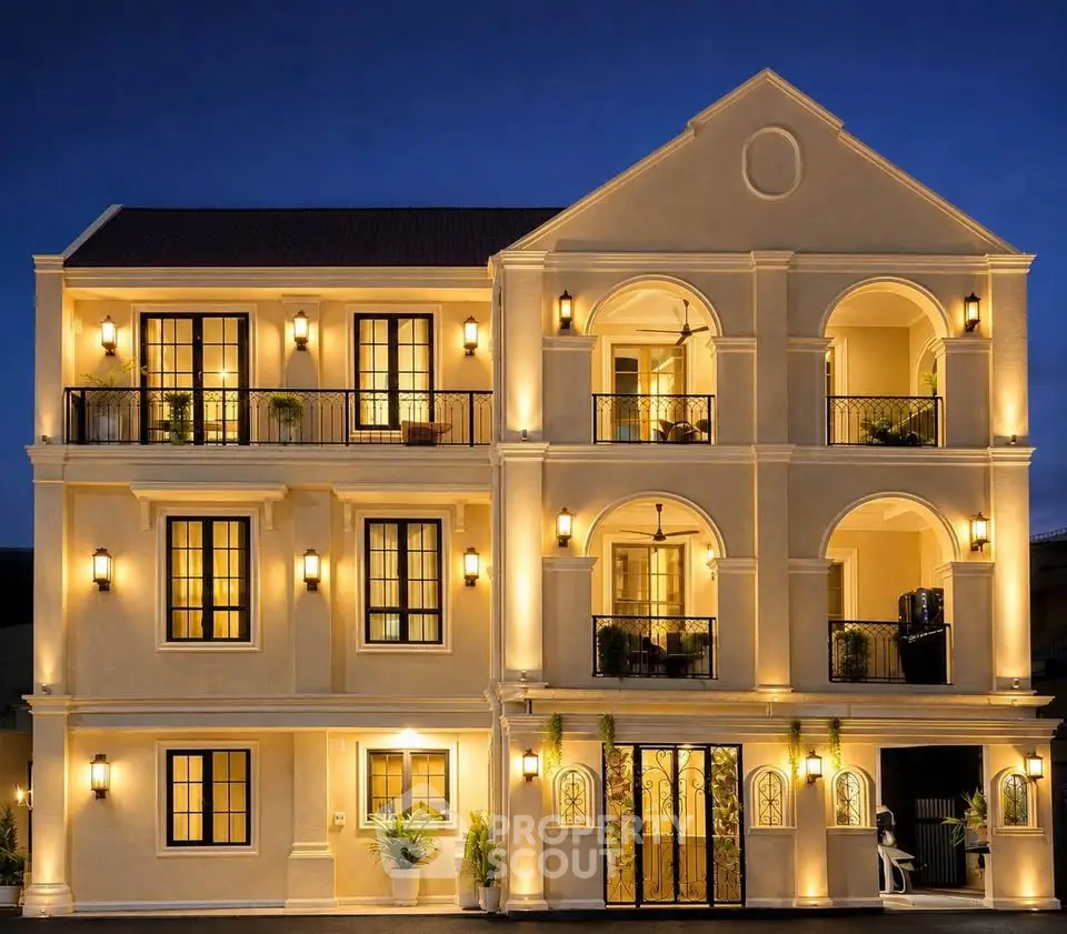 Stunning illuminated exterior of a luxury multi-story building with elegant arches and balconies at night.