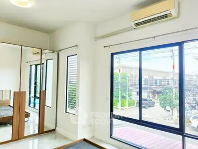 Bright bedroom with large windows and mirrored wardrobe, offering a modern and airy feel.