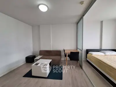 Modern studio apartment with minimalist furniture and sliding glass partition