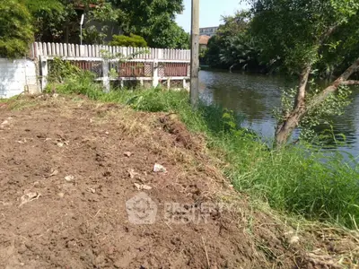 Scenic riverside plot with lush greenery and potential for development