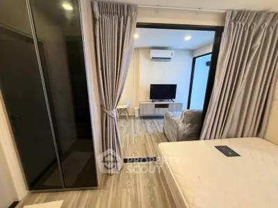 Modern studio apartment with open layout, featuring a cozy living area and sleek glass wardrobe.