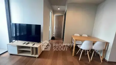 Modern living room with sleek TV setup and cozy dining area, perfect for urban living.