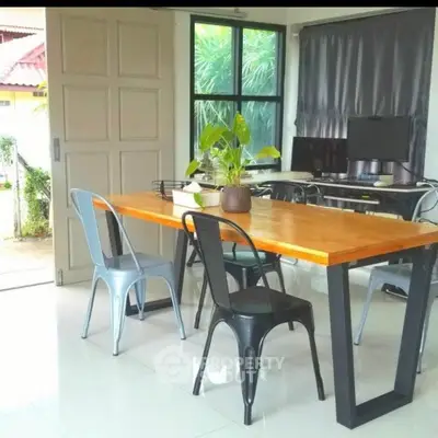 Modern home office with sleek desk, stylish chairs, and large window view.