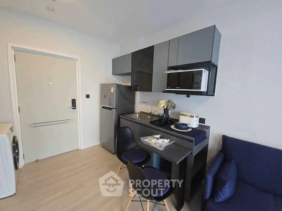 Modern compact kitchen with sleek cabinets and dining area in stylish apartment