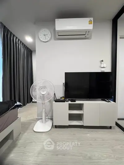 Modern bedroom with sleek design, featuring air conditioning, flat-screen TV, and stylish furnishings.