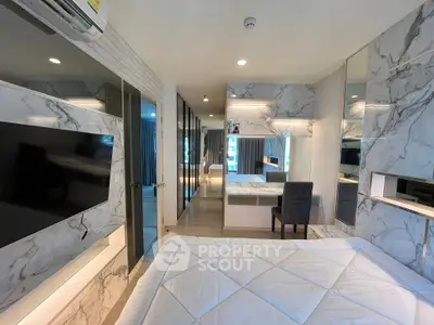 Luxurious modern bedroom with marble accents and large TV, perfect for stylish living.