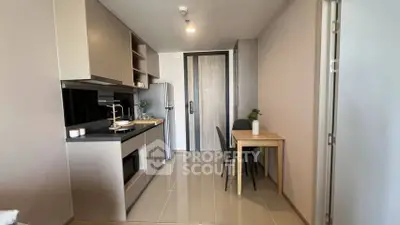 Modern kitchen with sleek cabinetry and dining area in a stylish apartment