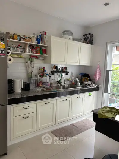 Charming kitchen with white cabinets and modern appliances, perfect for culinary enthusiasts.