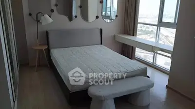 Spacious bedroom with large windows and modern decor in a high-rise apartment.