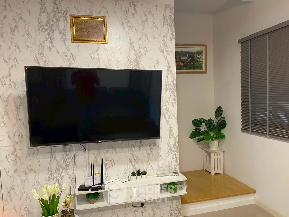 Modern living room with marble accent wall and large flat-screen TV