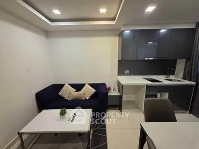 Modern living room with sleek kitchen, cozy sofa, and elegant decor in open layout apartment.