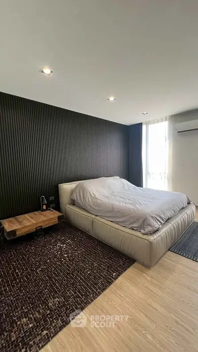 Modern bedroom with stylish dark accent wall and cozy bed setup