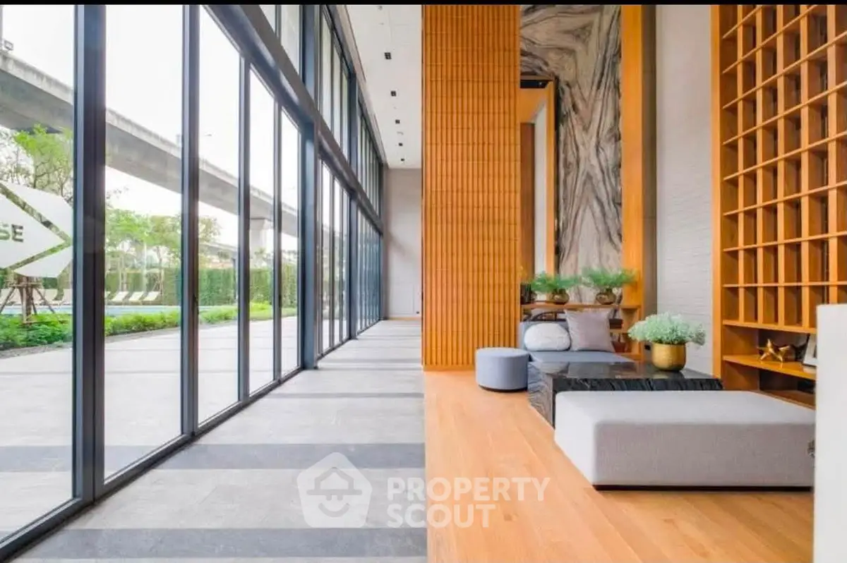 Modern building entrance with floor-to-ceiling windows and stylish interior design.