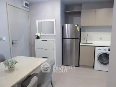 Modern kitchen with stainless steel fridge and washing machine in compact apartment