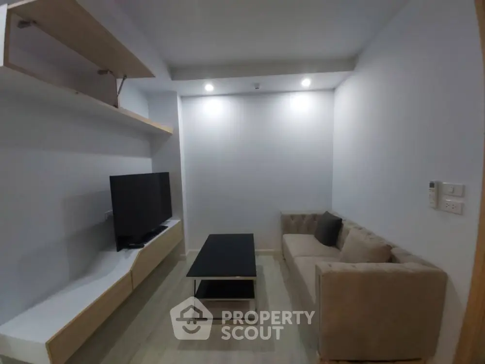 Modern living room with sleek TV setup and cozy sofa