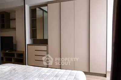 Modern bedroom with sleek built-in wardrobe and cozy bed, perfect for urban living.