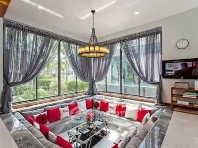 Luxurious sunken living room with elegant decor and large windows offering garden views.