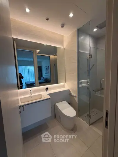 Modern bathroom with sleek design, featuring a glass shower and elegant fixtures.