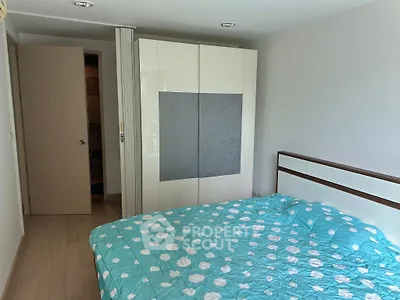 Cozy bedroom with modern wardrobe and stylish bedspread in a bright apartment.