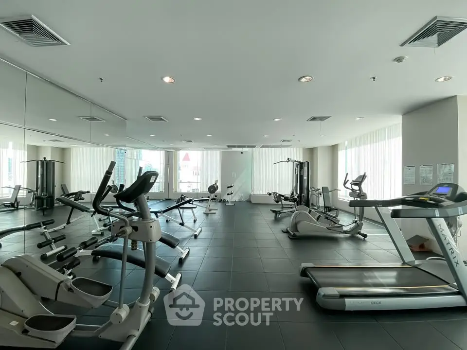Spacious modern gym with state-of-the-art fitness equipment and large mirrors.
