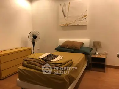Cozy bedroom with modern decor and warm lighting, featuring a single bed and stylish furniture.